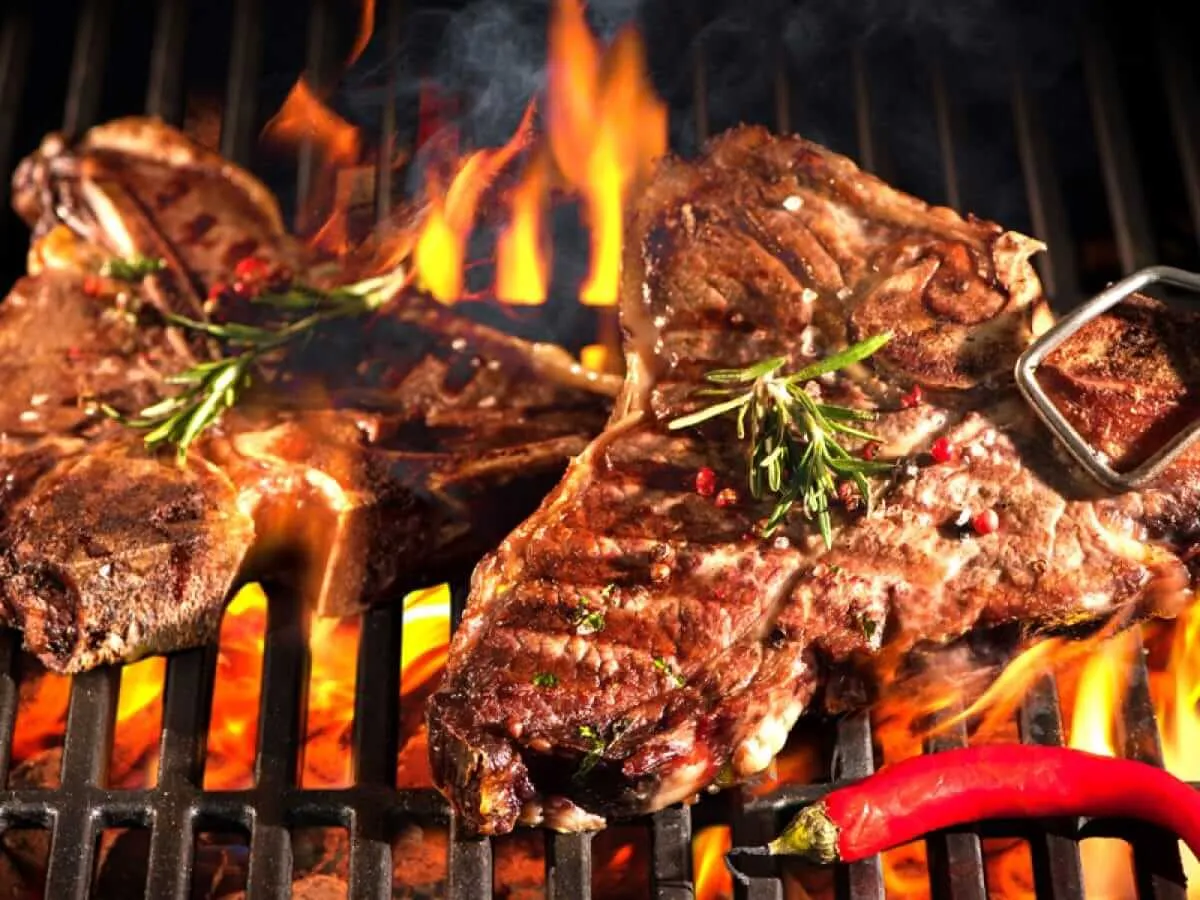 T-bone steaks with rosemary on a flaming grill
